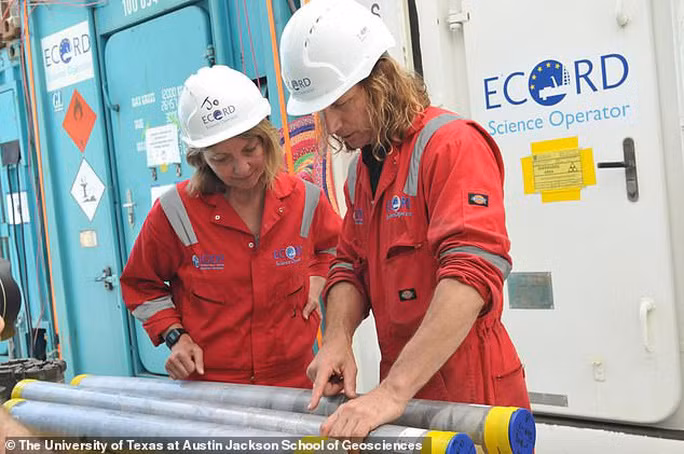 Các nhà khoa học đang nghiên cứu các ống mẫu vật lấy lên từ đáy hố va chạm - ảnh: ĐH Texas.