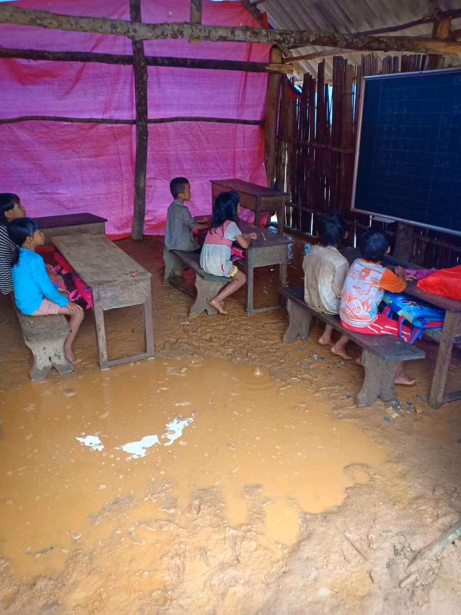 Lớp học được che chắn bởi tấm bạt, mưa to, thầy trò ướt như chuột. Ảnh: TG