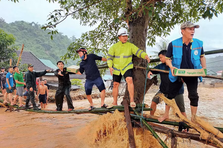 Đường vào bản Sơn Hà, xã Tà Cạ bị chia cắt do nước lũ chảy xiết, lượng lượng chức năng và người dân phải bắc cầu tre để đưa nhu yếu phẩm vào tiếp tế và sơ tán người dân ra ngoài.