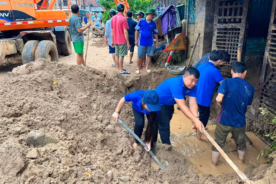 Đoàn thanh niên huyện Kỳ Sơn giúp người dân cào bùn, đất ra khỏi nhà.