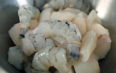 Làm sạch tôm, mực, bỏ vỏ đầu đuôi và chỉ lưng tôm. Rồi cho tất cả cùng cá vào thố lớn, thêm hành tỏi băm nhỏ, muối, đường, tiêu xay, 15ml dầu thực vật, bột mì, bột ngô, lòng trắng trứng vào chung, trộn đều tất cả và để ướp một lúc.