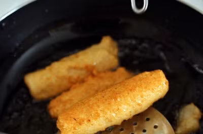 Đến khi chả chuyển màu vàng đều khắp các mặt thì bạn vớt ra đặt lên khăn ăn cho ráo dầu, rồi lần lượt làm đến khi hết nguyên liệu.