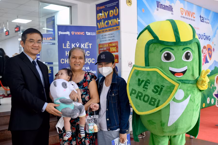 Ông Nguyễn Quang Trí – Giám đốc Điều hành Vinamilk, tặng quà cho các gia đình, các bé đến tiêm ngừa tại Trung tâm VNVC trong ngày kí kết hợp tác. Ảnh: Vi Nam