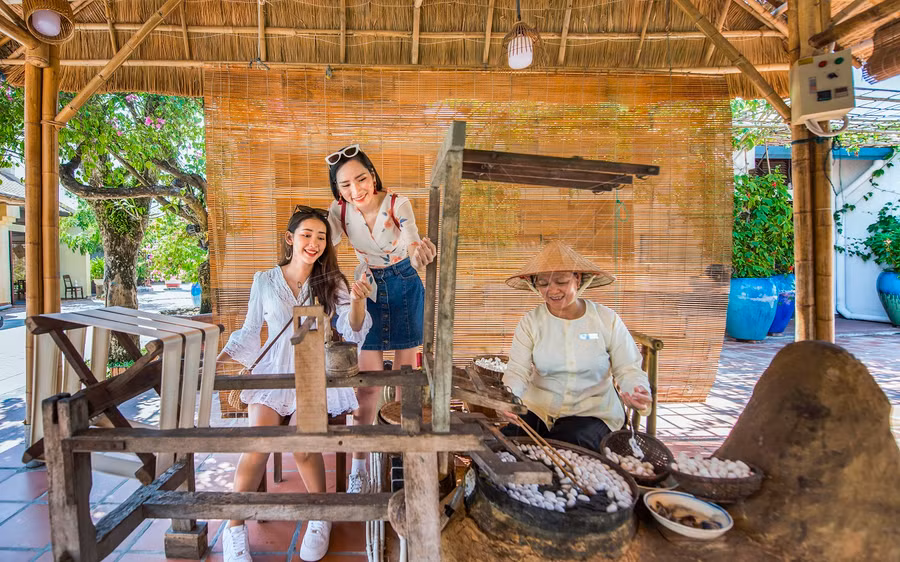 Du khách hóa thân thành nghệ nhân dệt lụa tơ tằm.