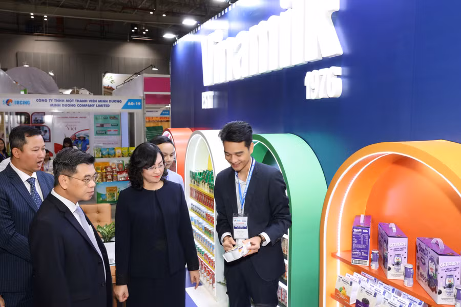: Ông Võ Trung Hiếu giới thiệu các sản phẩm xuất khẩu của Vinamilk với bà Phan Thị Thắng, Thứ trưởng Bộ Công Thương cùng các đại biểu tham quan triển lãm.