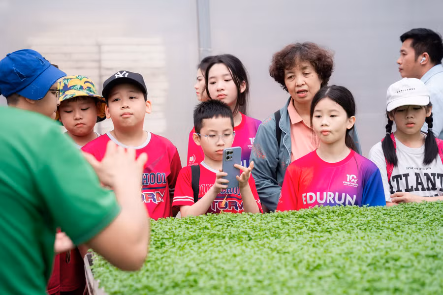 Các bạn hào hứng chụp ảnh nhà mầm và đặt các câu hỏi thú vị cho kỹ thuật viên nhà WinEco. Một bạn nhỏ chia sẻ rằng, chuyến tham quan này là một trải nghiệm thú vị giúp cậu bạn hình dung rõ hơn về “đường đi” của những “bạn” mầm, từ nông trường cho đến khi trở thành những món ăn ngon.