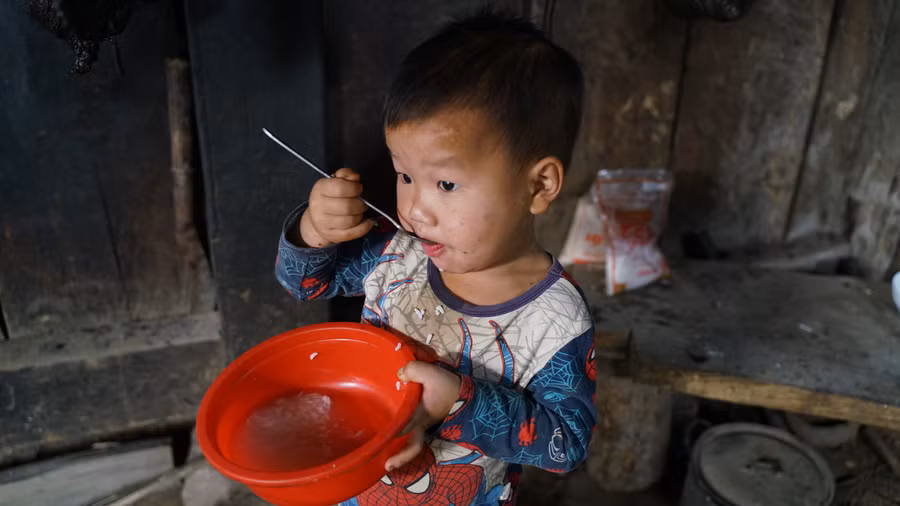 Bữa sáng cơm trộn nước sôi trong góc bếp nghèo nàn