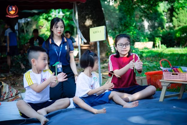 Thanh Trúc hướng dẫn các em nhỏ làm chong chóng. (Ảnh: Vietschool)