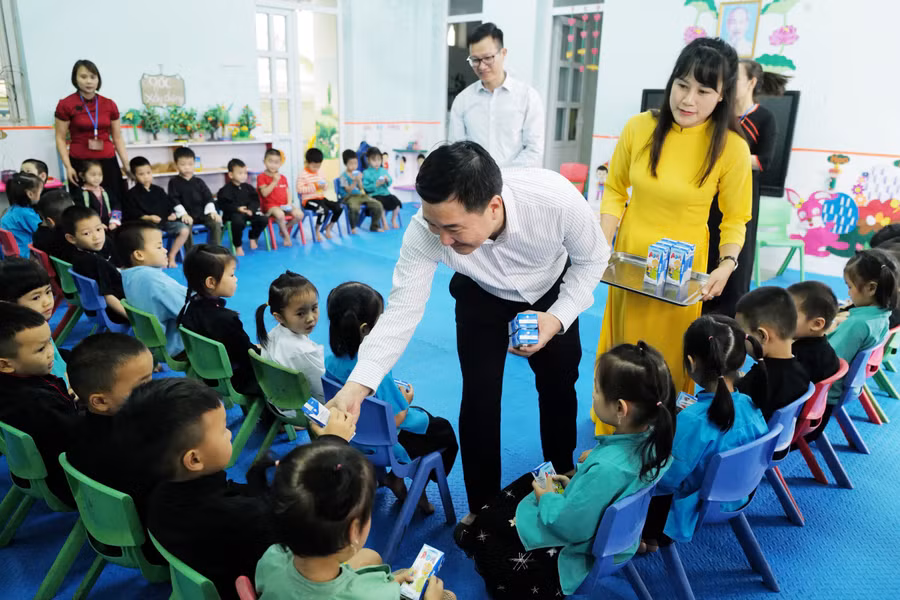 Các bé học sinh Trường Mầm non Vô Ngại ngồi ngay ngắn, háo hức chờ đón những hộp sữa.