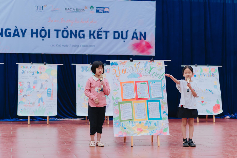 Hoàng Linh (phải) đang thuyết trình về tác phẩm báo tường của nhóm.