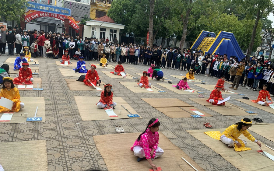 Học sinh mặc áo dài rực rỡ, thi viết thư pháp.