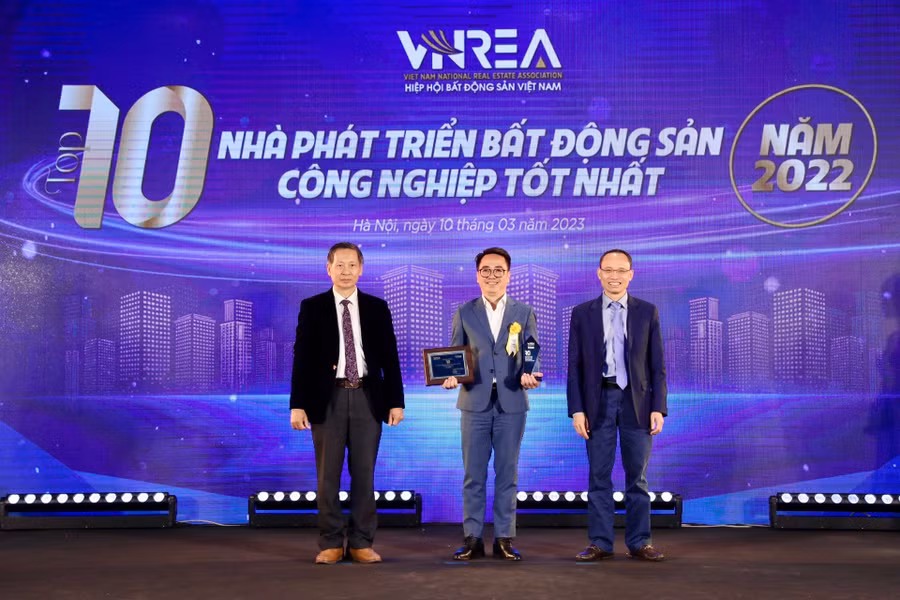 Ông Ngô Minh Giang, Giám đốc Ban Truyền thông &amp; Sự kiện (giữa), đại diện lãnh đạo Tập đoàn lên nhận cúp và chứng nhận Top 10 nhà phát triển bất động sản công nghiệp tốt nhất Việt Nam năm 2022