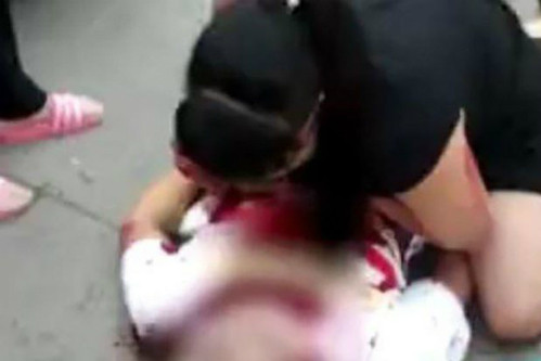 Người mẹ đau đớn ôm con trai mất mạng khi cố gắng bảo vệ mình. Ảnh:Scmp. Người mẹ đau đớn ôm con trai mất mạng khi cố gắng bảo vệ mình. Ảnh: Scmp.