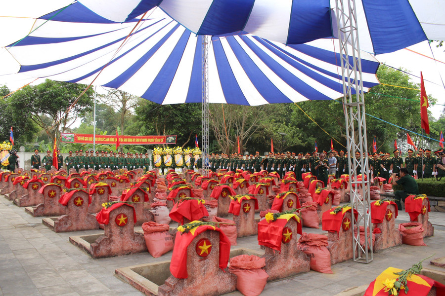 Các phần mộ liệt sĩ được trải hoa và Quốc kỳ. Các phần mộ liệt sĩ được trải hoa và Quốc kỳ.