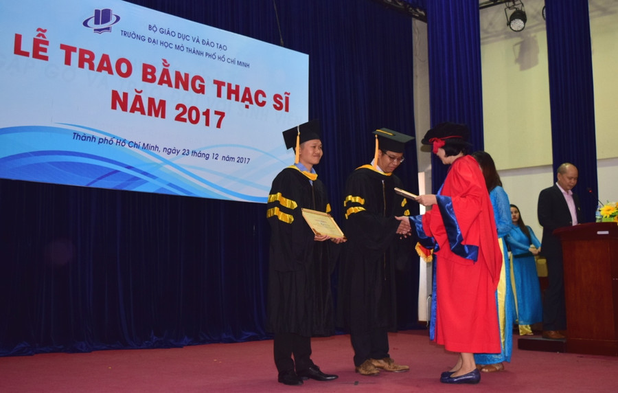 Đại diện một khoa lên trao bằng tốt nghiệp cho học viên