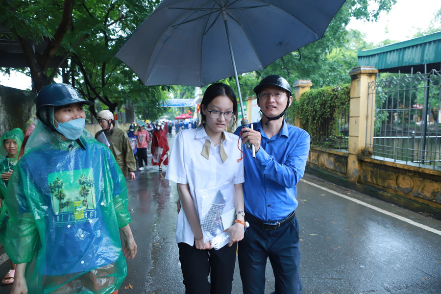 Anh Tuấn Anh che ô và hỏi thăm, động viên con gái sau giờ thi.