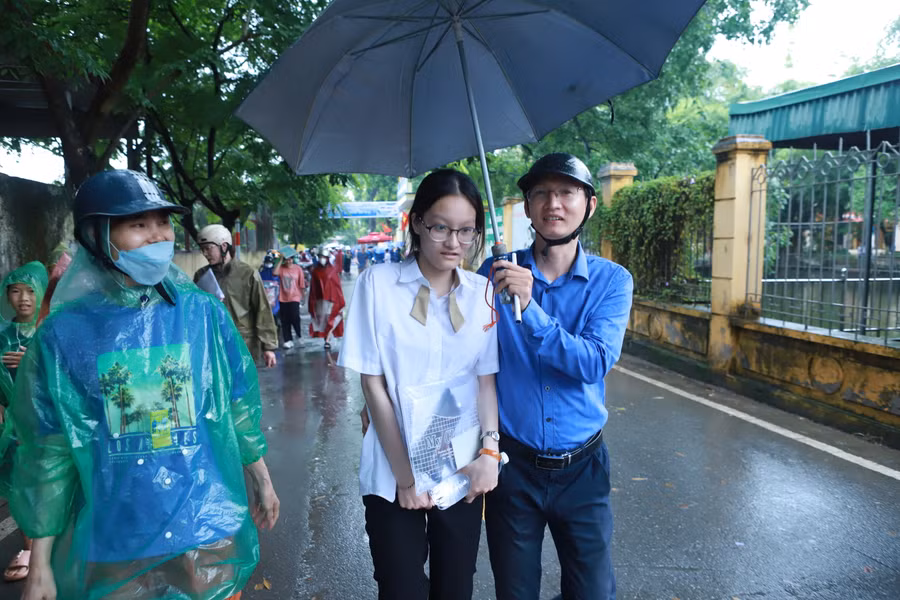 Anh Tuấn Anh che ô và hỏi thăm, động viên con gái sau giờ thi.