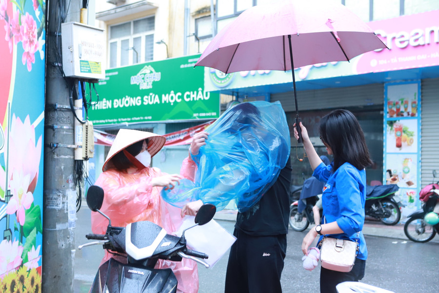 Thí sinh được người nhà đưa đến điểm thi và được thanh niên che ô từ tận cổng. Thí sinh được người nhà đưa đến điểm thi và được thanh niên che ô từ tận cổng.