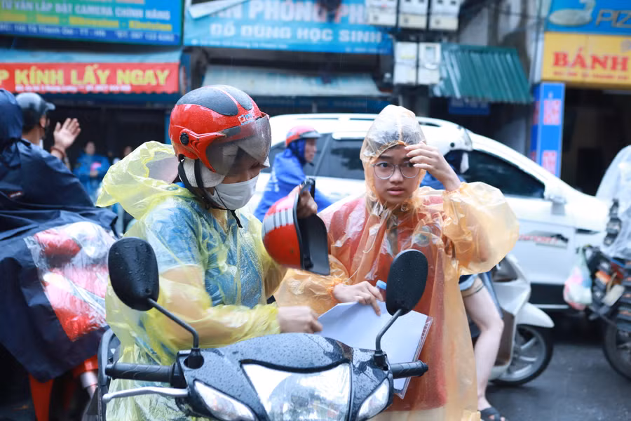 Dù có mưa nhưng phụ huynh không quên mang cho con đầy đủ các giấy tờ cần thiết như thẻ dự thi, CCCD, bút viết, bút chì, tẩy... trước khi vào phòng thi.