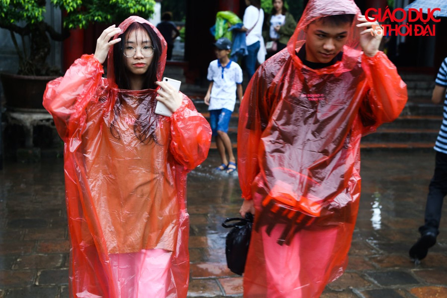 Các sĩ tử đến văn miếu trong cơn mưa nặng hạt.