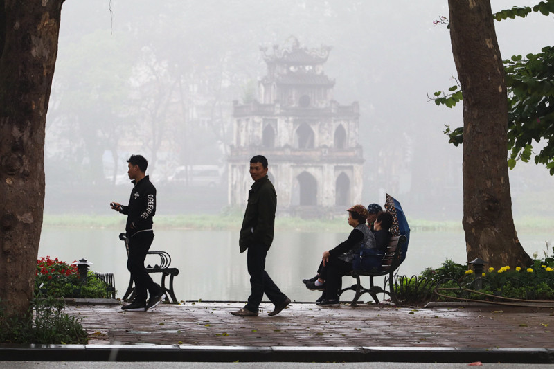 Tại khu vực bờ hồ Hoàn Kiếm, lớp sương mù dày đặc làm cho Tháp Rùa mờ ảo trong làn sương