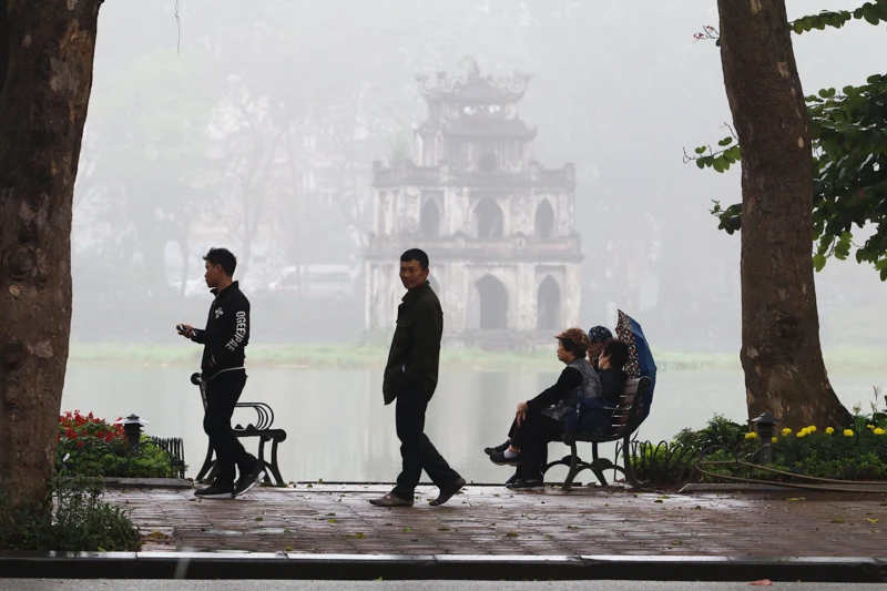 Tại khu vực bờ hồ Hoàn Kiếm, lớp sương mù dày đặc làm cho Tháp Rùa mờ ảo trong làn sương