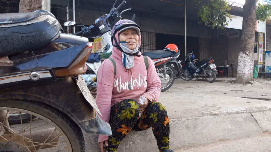 Chị Y Sin co ro trong giá lạnh những ngày cuối năm đợi “chủ” đến đưa vào rẫy hái cà phê. Ảnh: Trúc Hân.