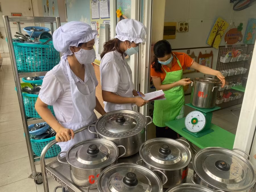 Đến giờ ăn, nhân viên nuôi dưỡng tại Trường Mầm non Phú La (Hà Đông, Hà Nội) chia cơm và thức ăn tới từng lớp. 