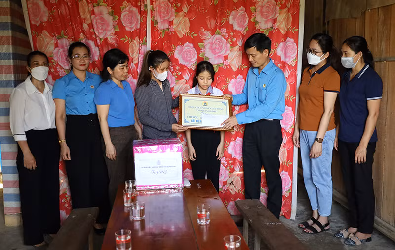 Lãnh đạo LĐLĐ tỉnh Quảng Bình trao tiền hỗ trợ cho cháu Trần Hà Vy, xã Kim Hóa, huyện Tuyên Hóa (Ảnh: HC).