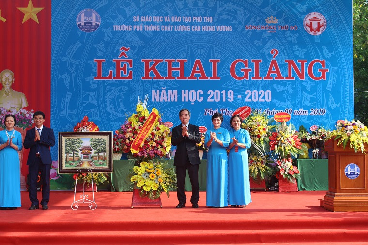 Ông Nguyễn Văn Bình tặng hoa, chụp ảnh lưu niệm cùng Ban giám hiệu nhà trường.