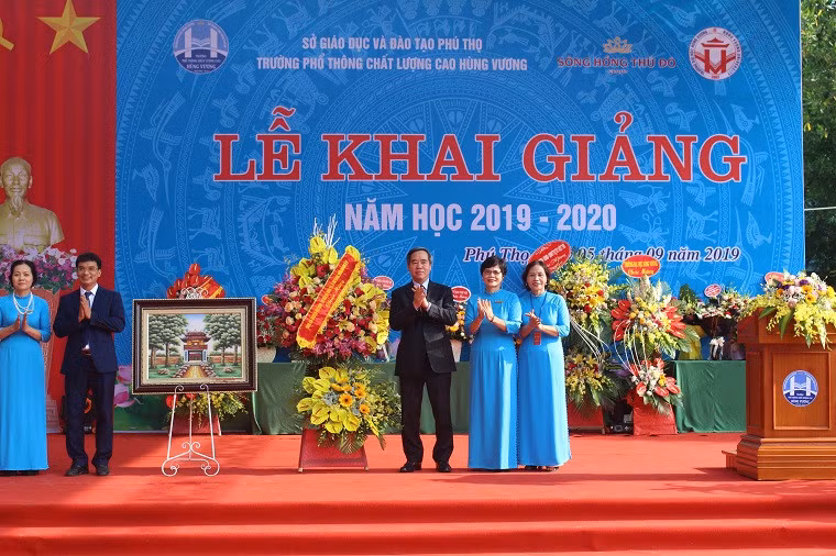 Ông Nguyễn Văn Bình tặng hoa, chụp ảnh lưu niệm cùng Ban giám hiệu nhà trường.