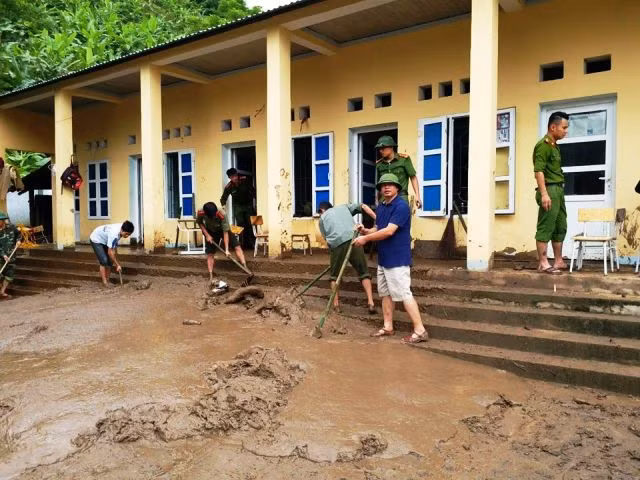 Lực lượng chức năng giúp trường Phổ thông Dân tộc bán trú - THCS Tam Chung, Mường Lát dọn dẹp sau lũ.
