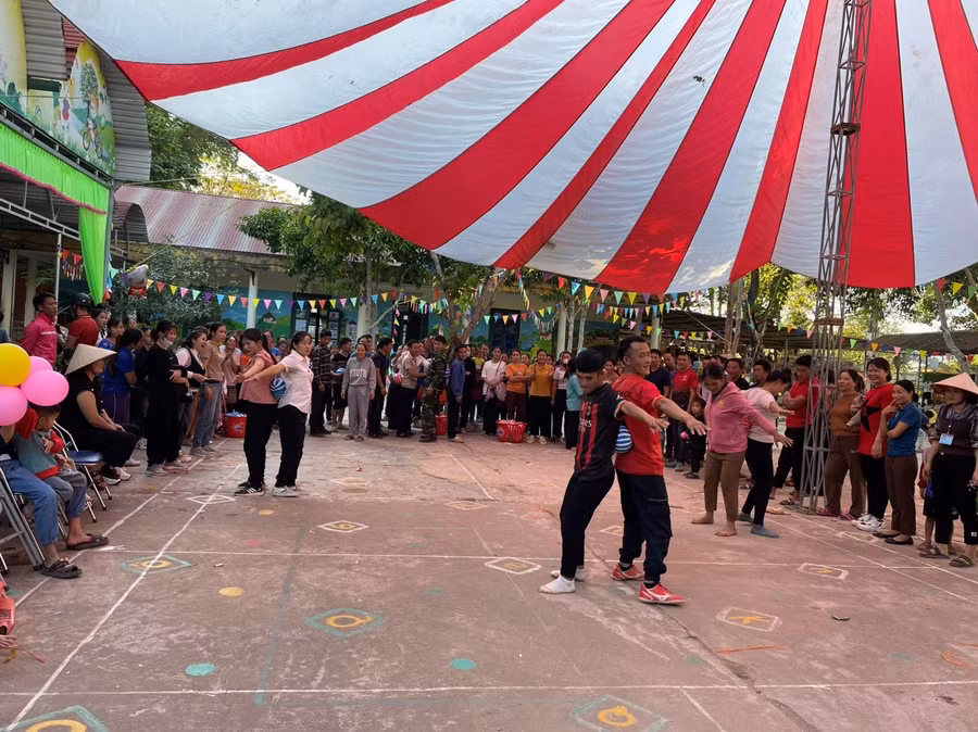 Phụ huynh và giáo viên nhà trường tham gia trò chơi đưa bóng bằng lưng.