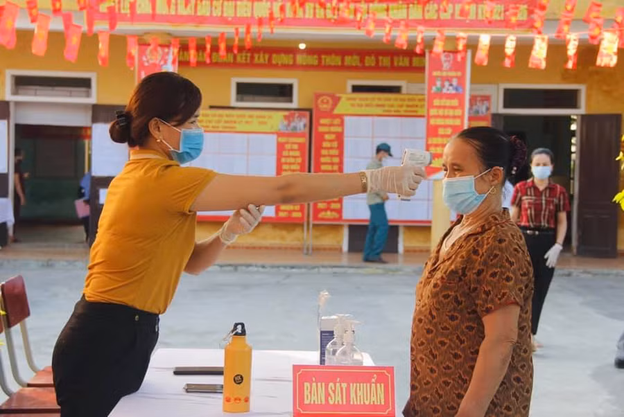 Công tác kiểm tra thân nhiệt tại các điểm bỏ phiếu.