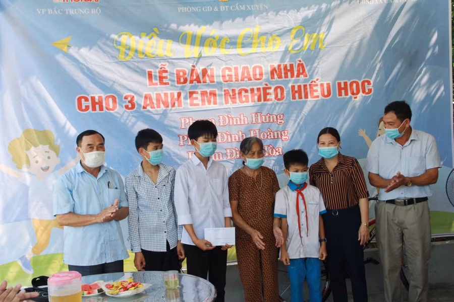 Trao quà cho 3 cháu tại lễ bàn giao nhà.