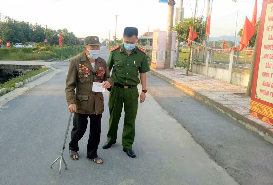 Cán bộ công an dìu người già đến tận điểm bầu cử.