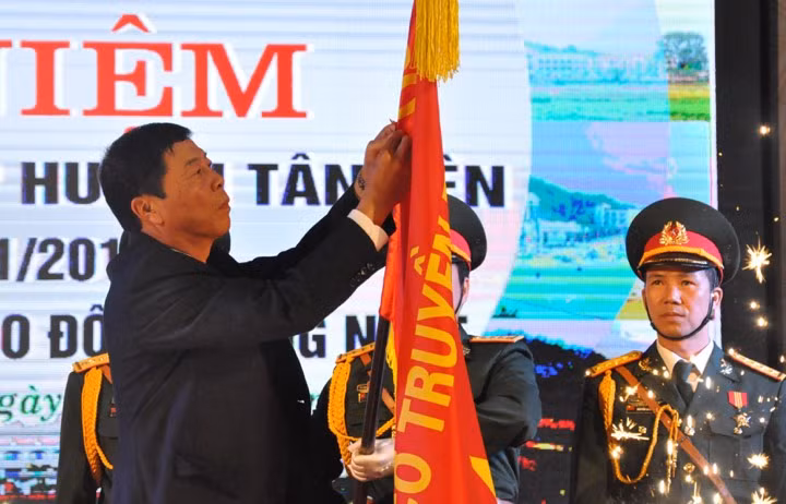 Ông Bùi Văn Hải - Bí thư Tỉnh ủy, Chủ tịch HĐND tỉnh Bắc Giang - gắn Huân chương lên cờ truyền thống của huyện Tân Yên