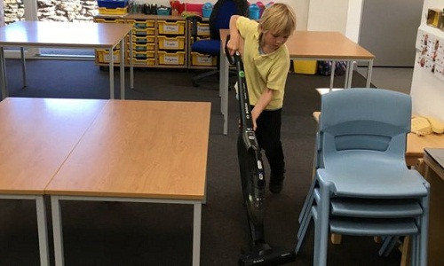 Học sinh sử dụng máy hút bụi ở lớp. Ảnh: BBC