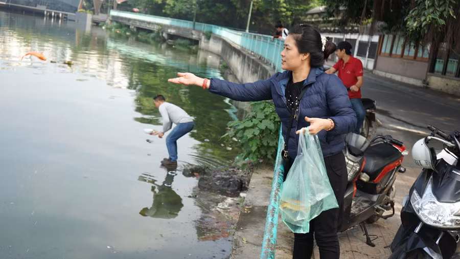 Tại khu vực Hồ Tây, người dân thả cá rất đông.