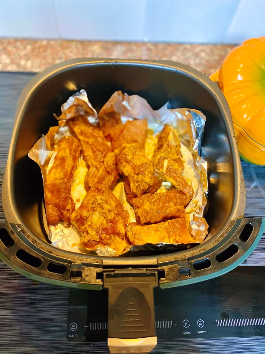 Sau 3h, lấy thịt ra xếp vào NCKD có lót giấy bạc phía dưới.