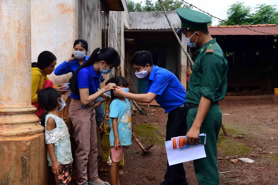 Bí thư Tỉnh Đoàn Bình Phước Trần Quốc Duy (ở giữa) cùng các bạn trẻ “đi từng ngõ, gõ từng nhà” để tuyên truyền về phòng chống dịch, tặng khẩu trang cho đồng bào dân tộc thiểu số tại địa phương.