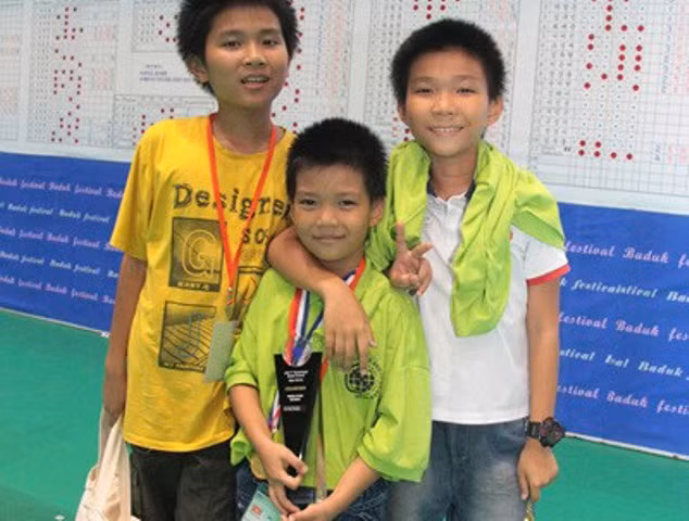 Đức Minh (giữa) bên hai anh trai sau khi đoạt HC vàng châu Á ở Hàn Quốc. 