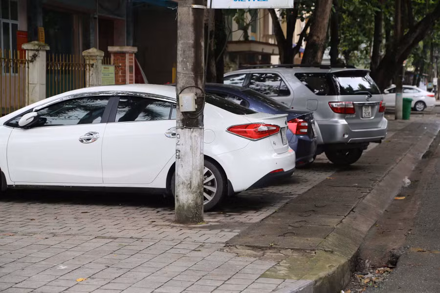Dãy ô tô lấn hết phần vỉa hè dành cho người đi bộ