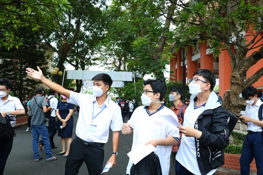 Tình nguyện viên hướng dẫn thí sinh tham dự kỳ thi ĐGNL của ĐHQG TPHCM vào phòng thi.