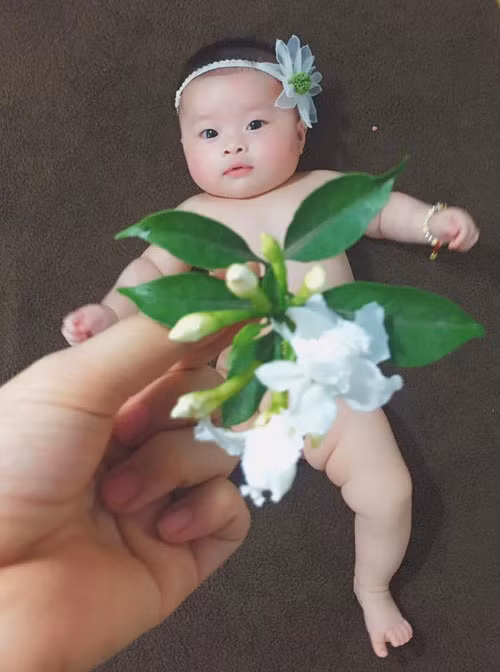 Thấy mẹ đưa bông hoa đỏ, miếng hoa quả hay chiếc lá, cô bé quẫy đạp chân tay, cười phấn khích và có nhiều biểu cảm trên gương mặt.