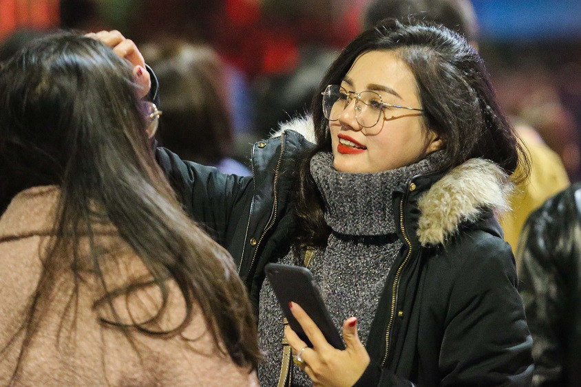 Những bạn trẻ chỉnh lại trang phục cho nhau để chụp những tấm hình kỷ niệm với năm 2018.