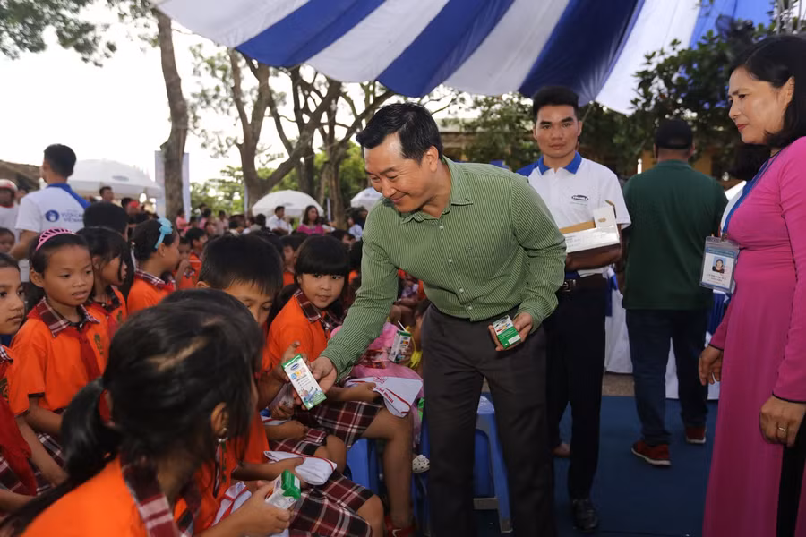 Ông Đỗ Thanh Tuấn - Giám đốc Đối Ngoại Vinamilk trao sữa cho các em nhỏ
