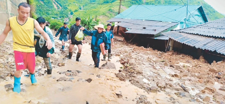 Sau cơn lũ, các thầy cô Trường Tiểu học Nhi Sơn và bà con tìm cách vào nhà lấy giấy tờ cho giáo viên 