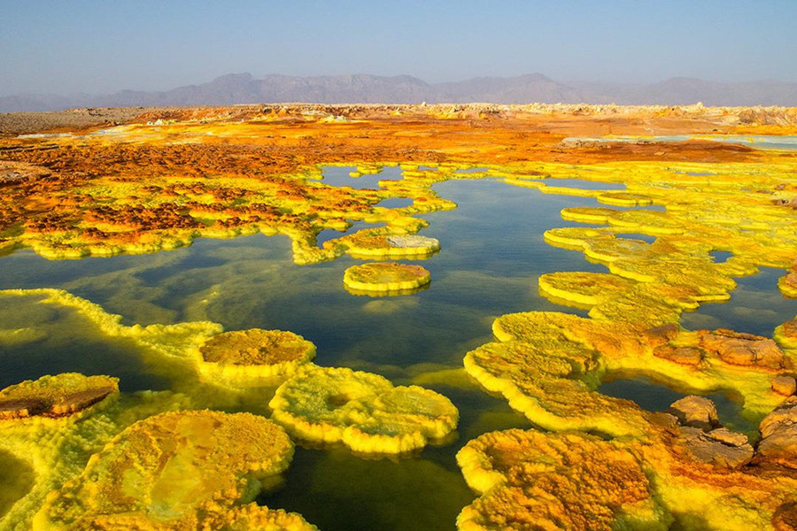 Hồ núi lửa Dallol (Ethiopia): Nằm giữa hoang mạc vùng trũng Danokil, Ethiopia, hồ núi lửa Dallol thu hút ánh nhìn bởi màu xanh, vàng bắt mắt. Đằng sau vẻ rực rỡ đấy, hồ nước là hố tử thần chứa đầy axit, lưu huỳnh, sắt và kim loại. Nồng độ hóa chất độc hại ở đây đạt mức cao. Ảnh: Tourist life. Loat