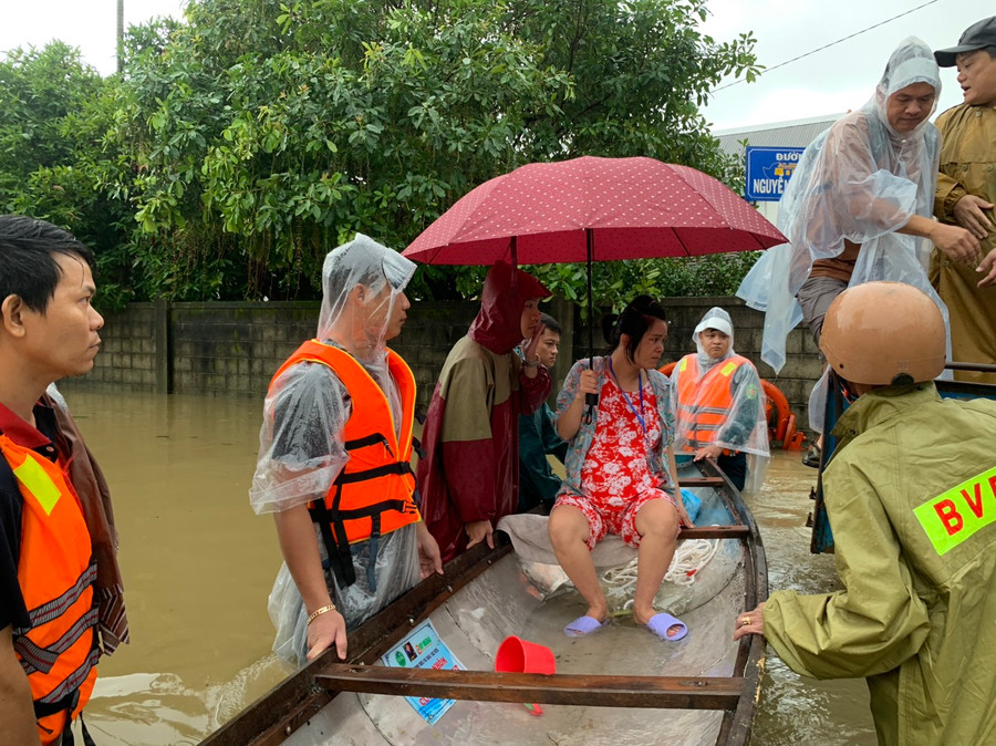Công an đưa thai phụ lên ghe vượt lũ đến bệnh viện sinh. (Ảnh: CACC)